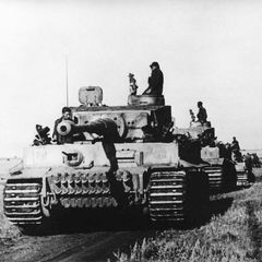 Schwarz-weiß-Foto, auf dem ein Kampfpanzer im Zweiten Weltkrieg über ein Feld rollt