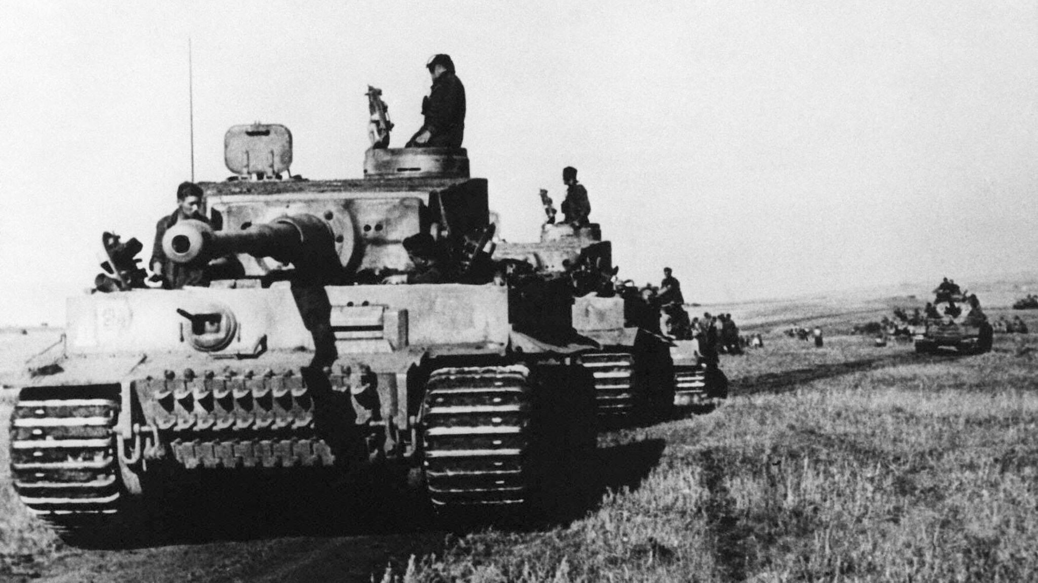 Schwarz-weiß-Foto, auf dem ein Kampfpanzer im Zweiten Weltkrieg über ein Feld rollt