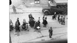Schwarz-weiß-Foto, das zeigt, wie SS-Truppen Juden im Warschauer Ghetto zusammentreiben