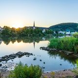 Blick über einen kleinen See auf einen Ort mit Kirchturm