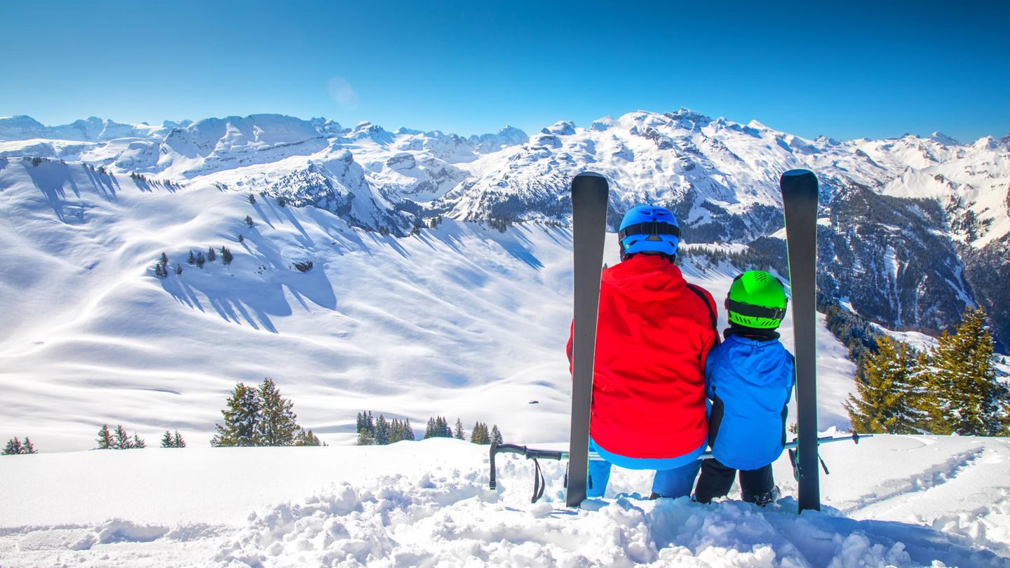 Ein Vater mit seinem Kind in einem Skigebiet