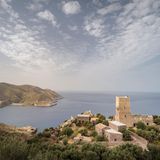 Es ist wie ein Blick in die Ewigkeit: Bis zum Horizont ziehen die Wolken über das weite Blau des Mittelmeers. Die Blätter der knorrigen Olivenbäume sirren leise im Wind, mal rufen Möwen. Und hinter der Kante des Infinitypools treibt das Auge über nichts als Inseln, Felsen, Wasser, Himmel. Die Aussicht vom alten Wehrturm an der Südspitze der griechischen Halbinsel Mani auf dem Peloponnes ist ein Spektakel der Stille. Intensiv und atemraubend. Es gibt keine Nachbarn, kein Töpfeklappern, kein Kindergeschrei. Weder hupende Autos, noch plärrende Gettoblaster. Nur dieses kleine, intime Hotel Tainaron Blue Retreat mit seinen vier Zimmern auf felsigem Grund. Die Architekten und Gastgeber Kostas Zouvelos und Kassiani Theodorakakou haben den denkmalgeschützten Turm des Forts aus dem 19. Jahrhundert zu einer Oase mit besonderem Flair gemacht: Balken und Deckengewölbe wurden freigelegt, moderne Duschen, Waschbecken und Schreibtische schmiegen sich an den alten Stein. Draußen liegen wir auf Outdoor-Betten, über denen weiße Stoffe flattern. Zum Frühstück gibt es Granatäpfel vom eigenen Feld, frisch gebratenes Omelett, Kuchen und Joghurt aus der Region, am Abend ein mehrgängiges, saisonales Menü. Es duftet nach Pinien, Meer und Sommerwärme. Erst wenn die Sonne still im Meer versunken ist, gehen wir wieder rein, und wollen weniger von hier weg als je zuvor.