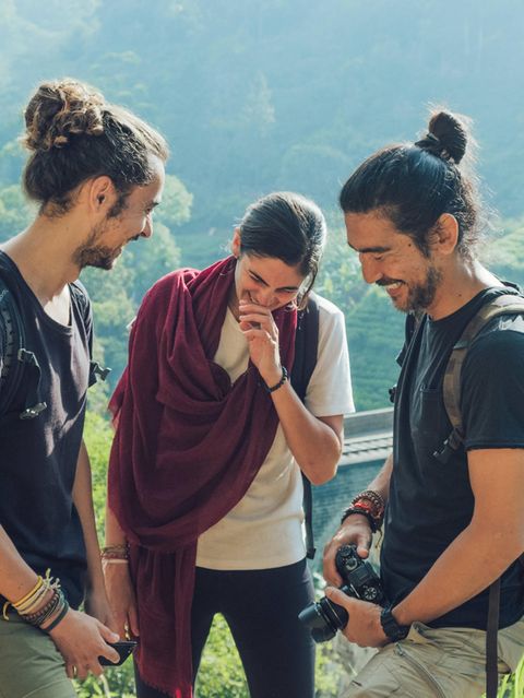 Drei Junge Menschen stehen in Sri Lank zusammen und lachen