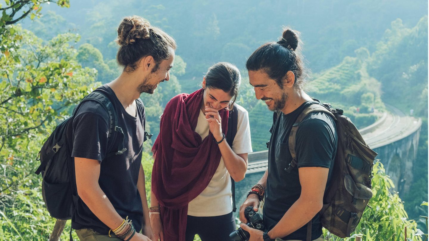 Drei Junge Menschen stehen in Sri Lank zusammen und lachen