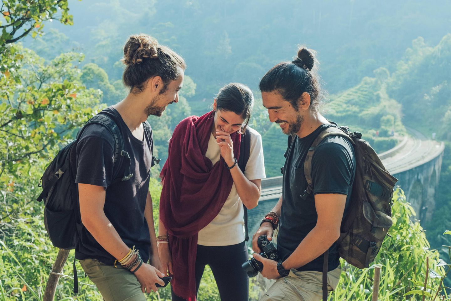 Drei Junge Menschen stehen in Sri Lank zusammen und lachen