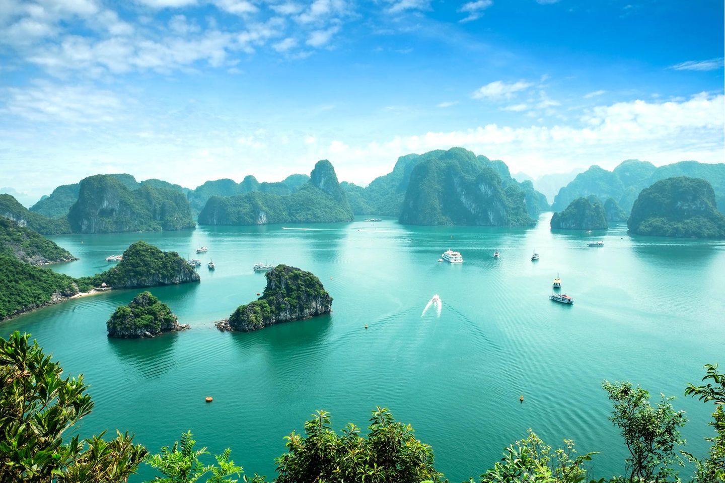 Bucht von Halong mit türkisfarbenem Wasser und begrünten Felsen, die aus dem Wasser ragen