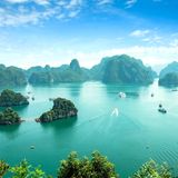 Bucht von Halong mit türkisfarbenem Wasser und begrünten Felsen, die aus dem Wasser ragen