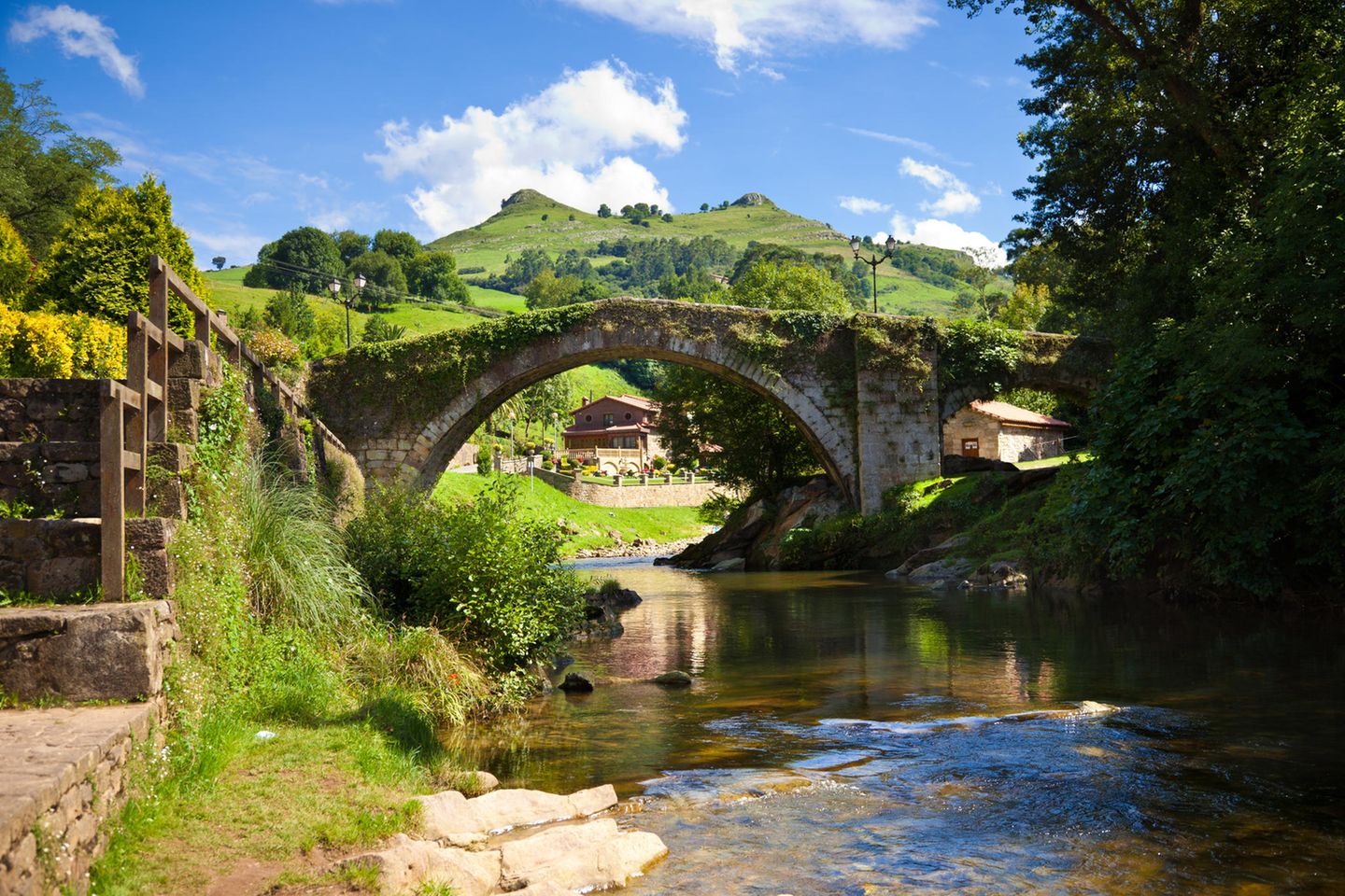 Eine alte Brücke über einem schmalen Fluss
