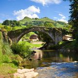 Eine alte Brücke über einem schmalen Fluss