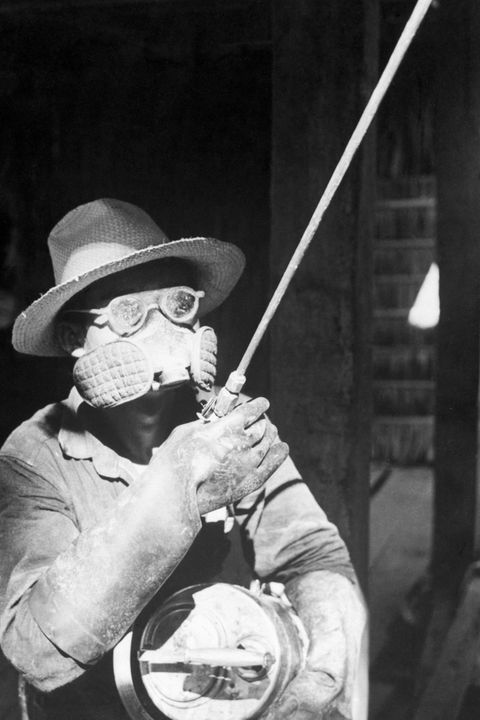 Ein versprüht in Schutzkleidung das noch giftigere Dieldrin