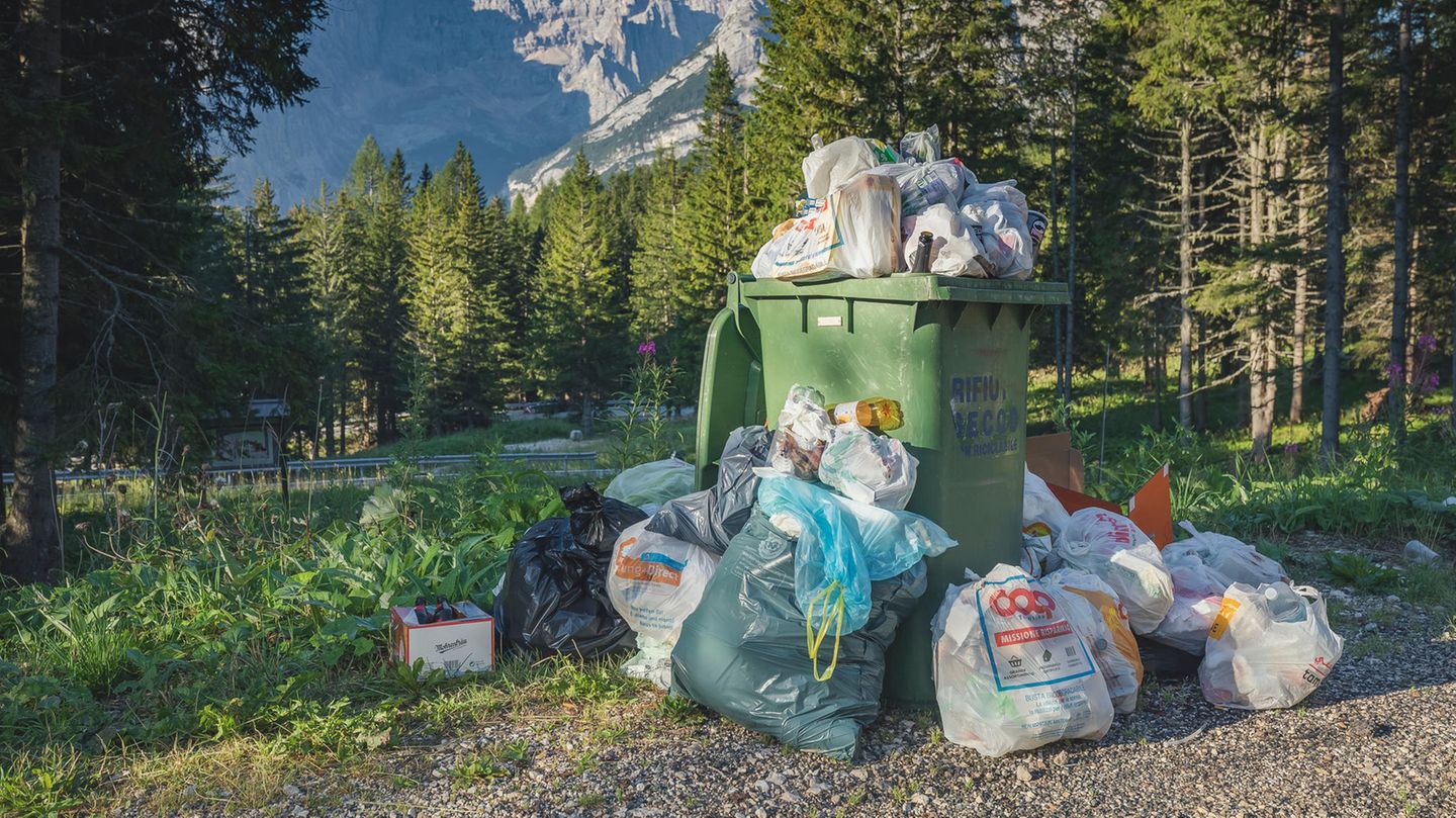 Ein überfüllter Abfalleimer in schönes Landschaft in den Alpen