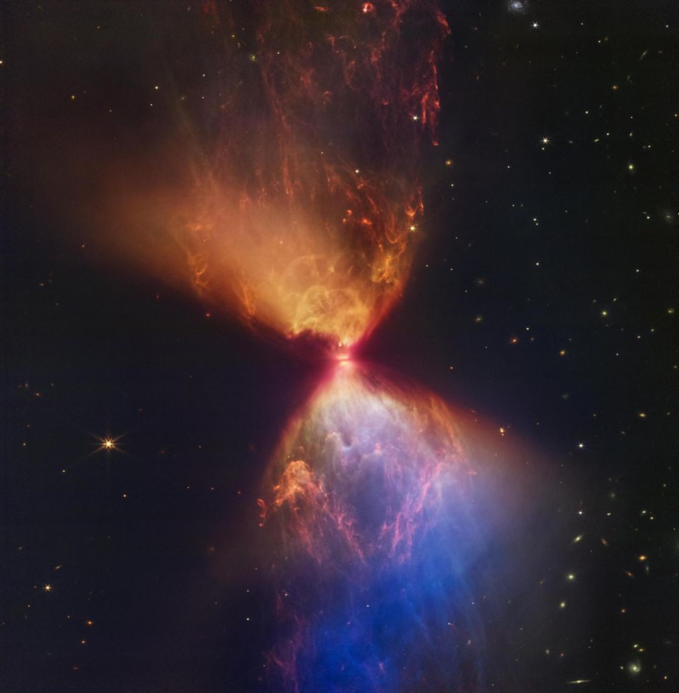 Der hier farbig dargestellte Dunkelnebel L1527 im Sternbild Stier erinnert an eine Sanduhr. In der Mitte befindet sich ein gerade mal rund 100 000 Jahre alter Protostern. Er zieht immer mehr Materie an, bis irgendwann in seinem Inneren die Kernfusion zündet und er selbst Energie freisetzt