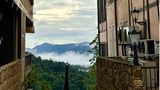 Blick zwischen zwei Fachwerkhäusern auf den nebelverhangenen Dschungel