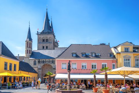 Bunte Hausfassaden an einem Platz mit einem Brunnen und einer Kirche