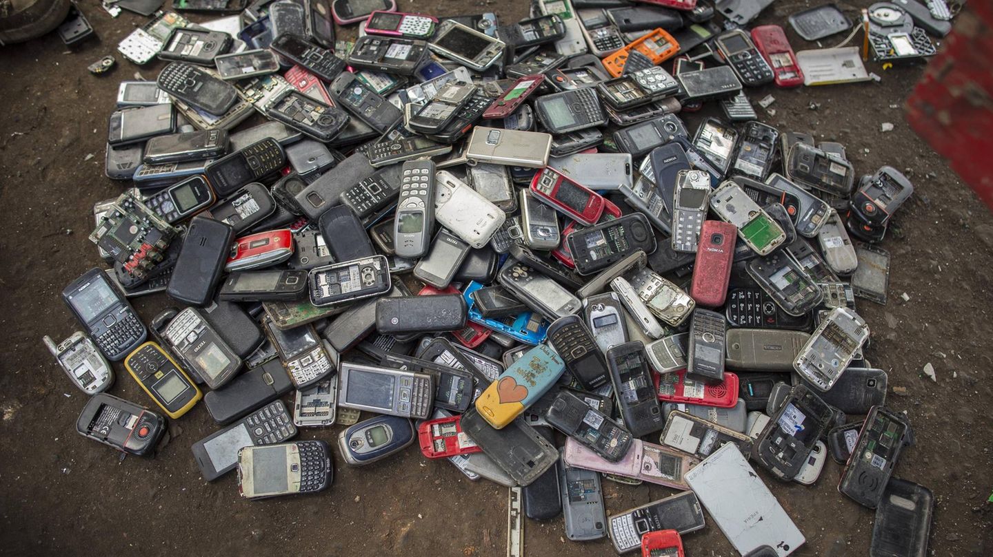 Ein Berg voller Smartphones liegt auf einem dreckigen Boden