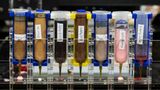 Sieben Behälter des Druckers mit verschiedenen Inhaltsstoffen wie Marmelade und Erdnussbutter