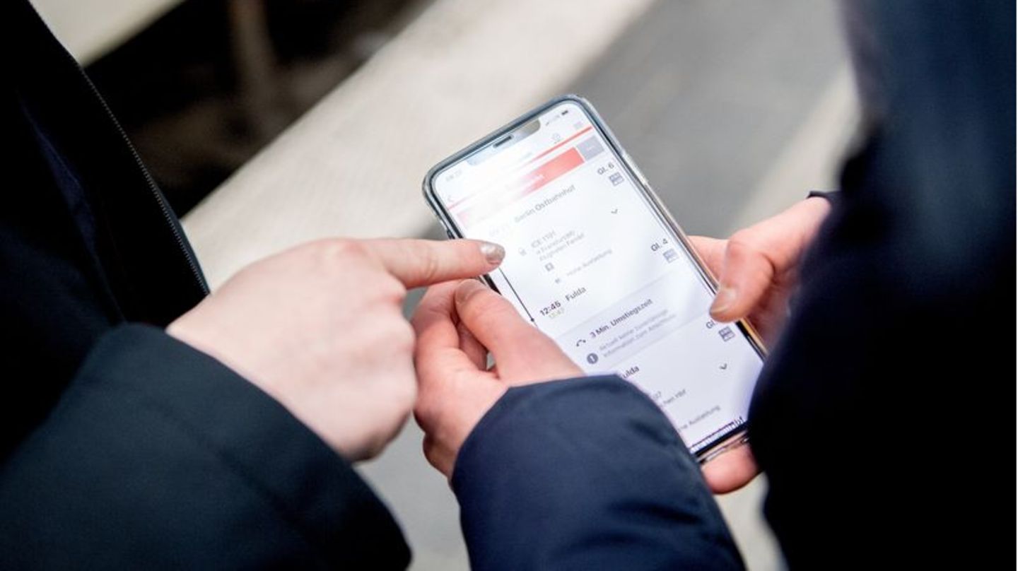 Hände mit Handy in der Hand, auf dem die DB Navigator-App geöffnet ist