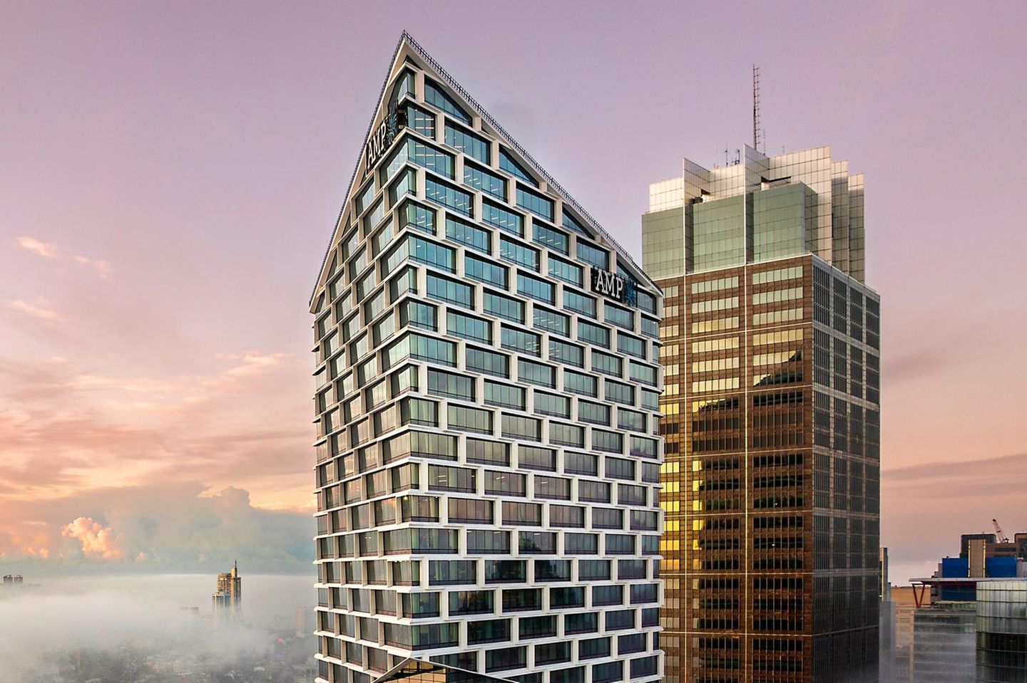 Hochhaus mit Glasfassade umgeben von Wolken