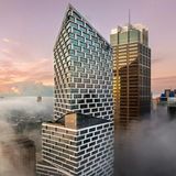 Hochhaus mit Glasfassade umgeben von Wolken