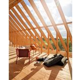 Blick ins Grüne aus einem Haus mit Holzpfeilern und viel Glas