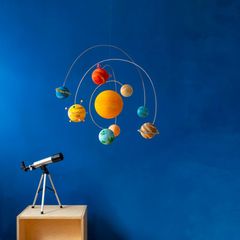 Planeten-Mobile basteln – Ein Mobile mit Planeten hängt vor einem blauen Hintergrund, links unten steht ein Fernrohr