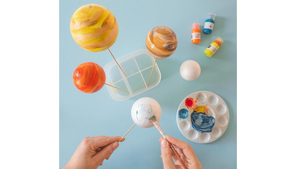 Planeten-Mobile selber basteln – Styroporkugeln werden mit Farbe bemalt, sodass sie wie Planeten aussehen