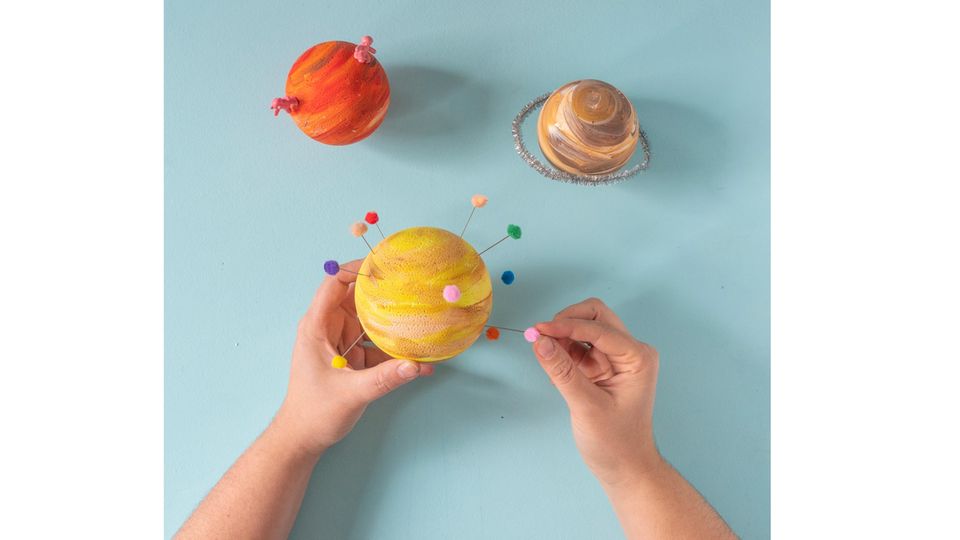 Planeten-Mobile selber basteln – Die Planeten aus Styropor werden mit Zahnstochern und Minibommeln verziert