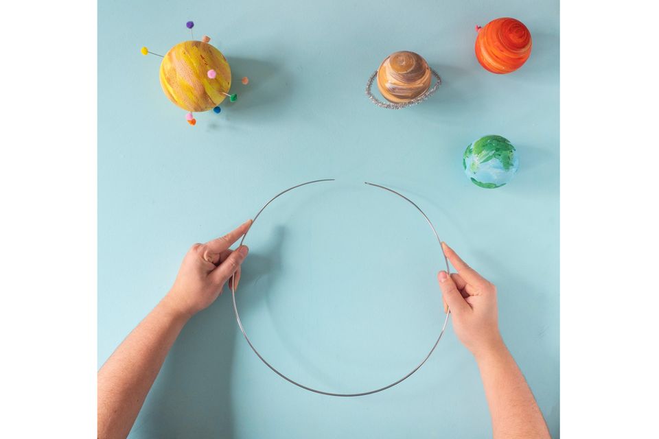 Planeten-Mobile selber basteln – Für das Mobile wird ein Metallring geöffnet, auf dem die Planeten aufgesteckt werden Planeten-Mobile selber basteln – Für das Mobile wird ein Metallring geöffnet, auf dem die Planeten aufgesteckt werden