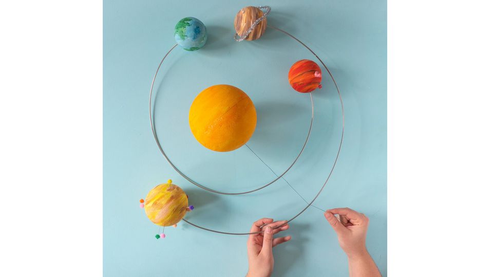 Planeten-Mobile selber basteln – Die Sonne wird mithilfe einer Schnur am Mobile befestigt
