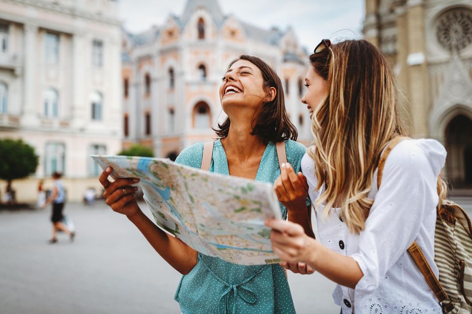Zwei Frauen im Urlaub mit einem Stadtplan in der Hand