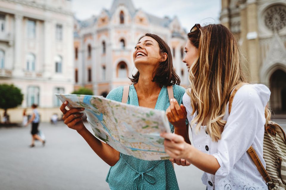 Zwei Frauen im Urlaub mit einem Stadtplan in der Hand  1.5004