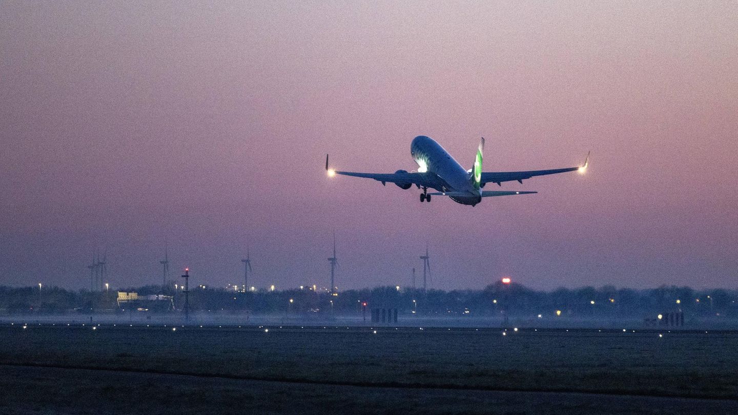 Flugzeug startet bei Nacht am Flughafen Schipohl