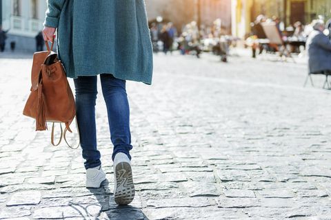 Junge Frau geht zu Fuß durch die Stadt