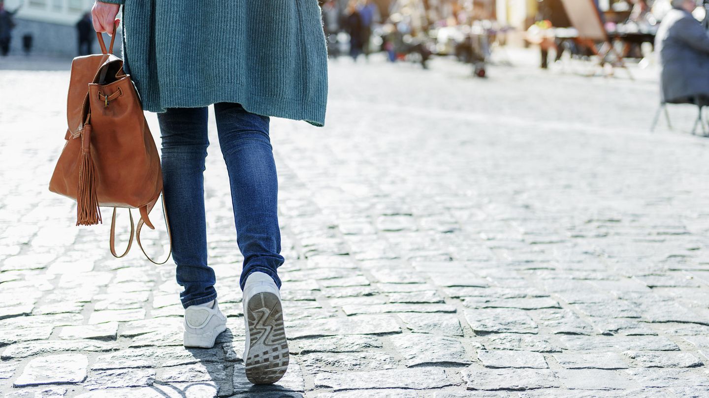 Junge Frau geht zu Fuß durch die Stadt