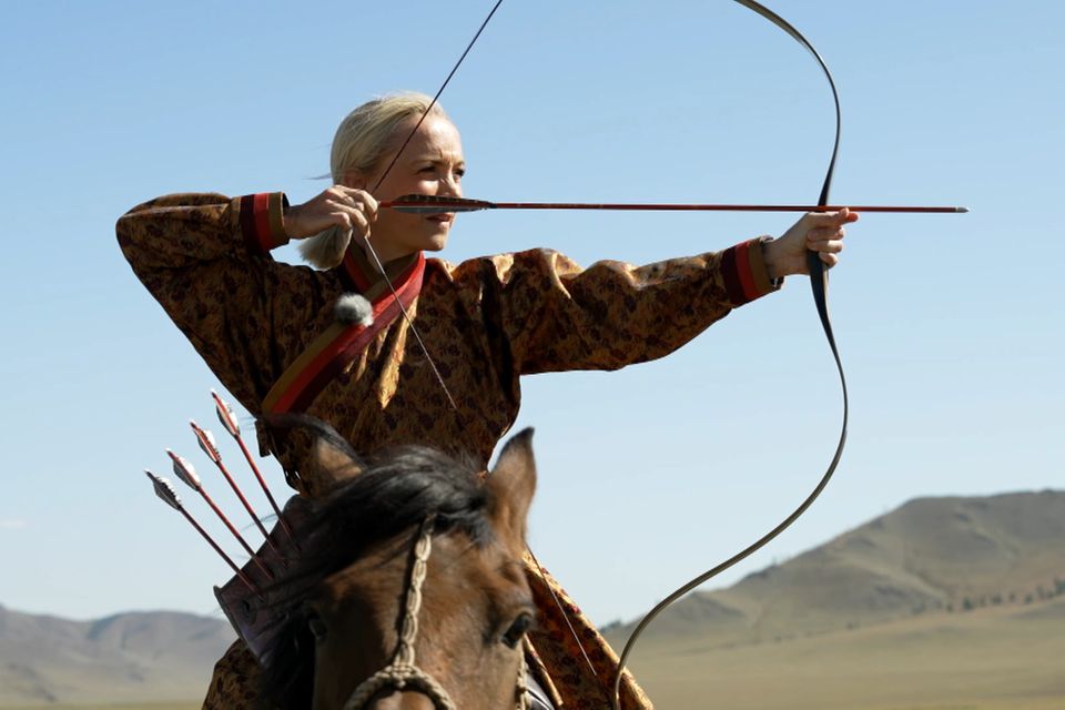 Janin Ullmann auf einem Pferd mit Pfeil und Bogen
