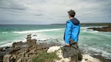 Ralph Caspers steht an einer Klippe und schaut auf das Meer