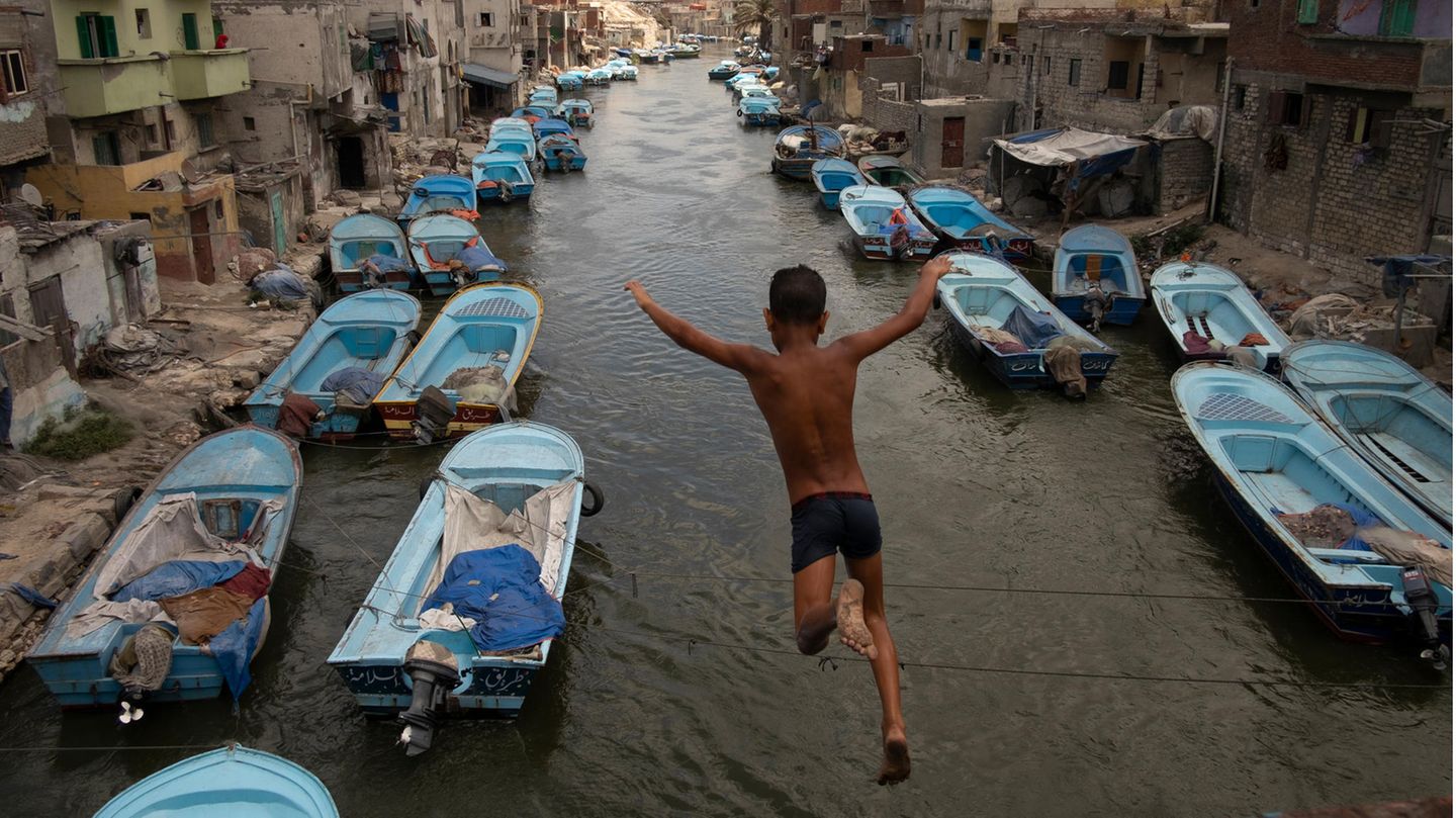 Gewinner in der Kategorie Offenes Format: "Here, The Doors Don't Know Me" von Mohamed Mahdy Ein Junge springt in einen Kanal, in dem viele blaue Boote liegen