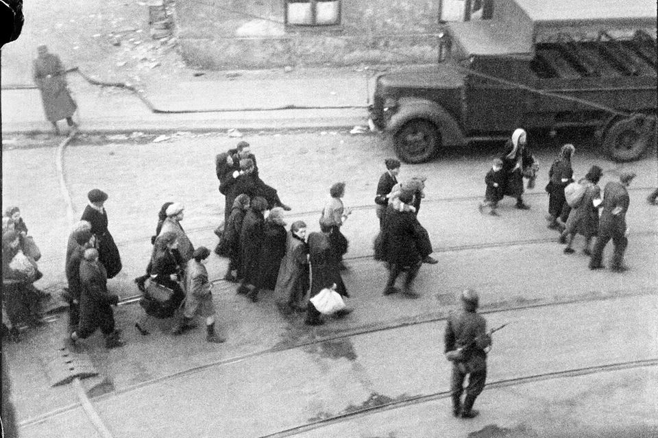 Schwarz-weiß-Foto, das zeigt, wie SS-Truppen Juden im Warschauer Ghetto zusammentreiben