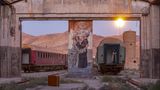 Die Zeit, in der Reisende auf dem Bahnhof Bonekouh hin und her hasteten, ist längst vergangen. Die Anlage nahe Garmsar ist ein Relikt aus der Ära der Pahlavi, jener Dynastie, der im Iran bis 1979 die letzten persischen Schahs entstammten. Inmitten der staubigen Trostlosigkeit zieht ein Liebespaar den Blick auf sich, überlebensgroß und friedvoll. Es scheint, als würden die zwei für einen Moment alles um sich herum vergessen, auch das Wasser, das ihnen schon bis an die Knie reicht. Gemalt hat das Wandbild die Künstlerin Razieh Iranpour. Bis sie sich unabhängig als Malerin einen Namen machen konnte, hat es Jahre gedauert. Mittlerweile stellt sie auch in Europa und den USA ihre Kunst aus