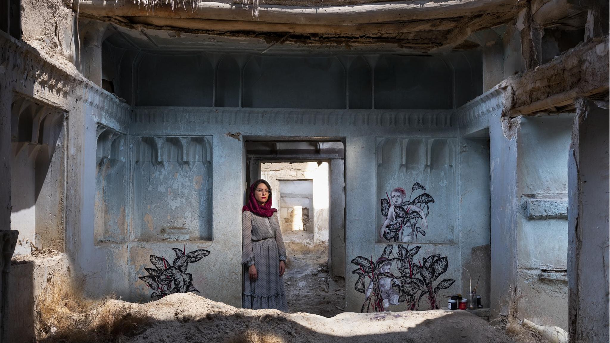 Pooneh Oshidari, geboren 1984 in Teheran  Das Haus mitten in Teheran ist rund 150 Jahre alt. Doch seit 40 Jahren steht es verlassen da, verfällt. Nur der Zierrat an den Mauern lässt noch erahnen, wie schön es einmal gewesen sein muss. Der Besitzer hat das Land verlassen und in den USA ein neues Leben angefangen. Nun hat die Künstlerin Pooneh Oshidari auf den blanken Wänden ein Bild der Zuversicht gemalt: Pflanzen recken ihre Blätter in die Höhe, so kraftvoll, dass Kinder auf ihnen klettern können. Allerorten erlebt die Künstlerin, wie Wasserknappheit im Iran die Landschaft verdorren lässt. Und so hat sie die Bedrohung der Umwelt zum Kern ihres Schaffens gemacht