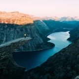 Eine Person steht im Abendlicht auf der Trolltunga