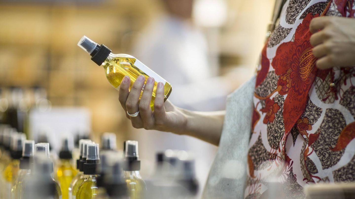 EIne Frau hält eine Flasche Parfum in der Hand