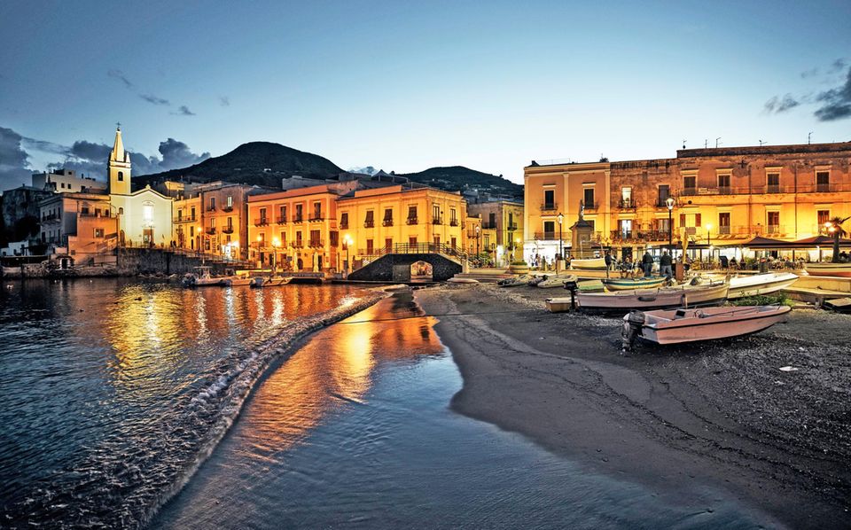 Die Äolischen Inseln: Wenn die Tagestouristen fort sind, kehrt im Hafen Ruhe ein. Das Gotteshaus San Giuseppe (l.) und die Promenade leuchten auch nach Sonnenuntergang Wenn die Tagestouristen fort sind, kehrt im Hafen Ruhe ein. Das Gotteshaus San Giuseppe (l.) und die Promenade leuchten auch nach Sonnenuntergang
