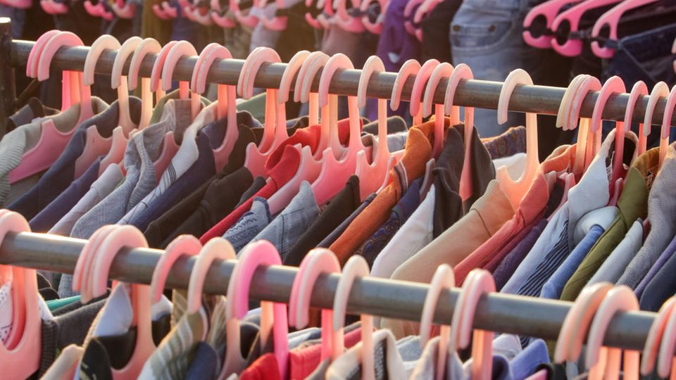 Hunderte Kleidungsstücken, aufgereiht auf Kleiderbügeln Hunderte Kleidungsstücken, aufgereiht auf Kleiderbügeln