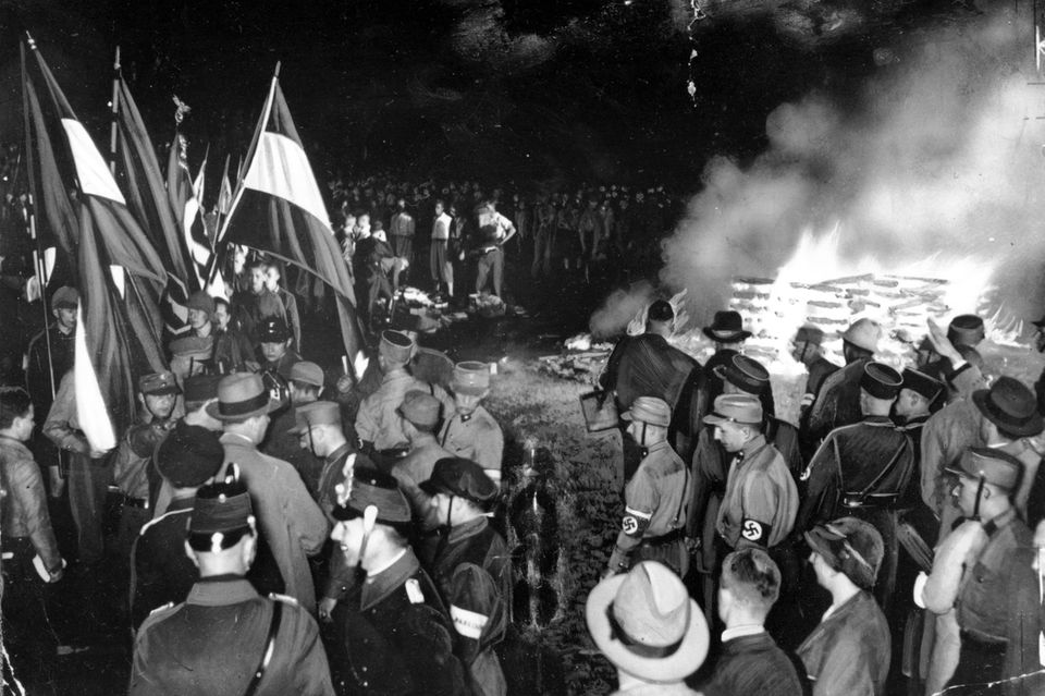 Männer in Nazi-Uniformen verbrennen Bücher (Datum: 10. Mai 1933)