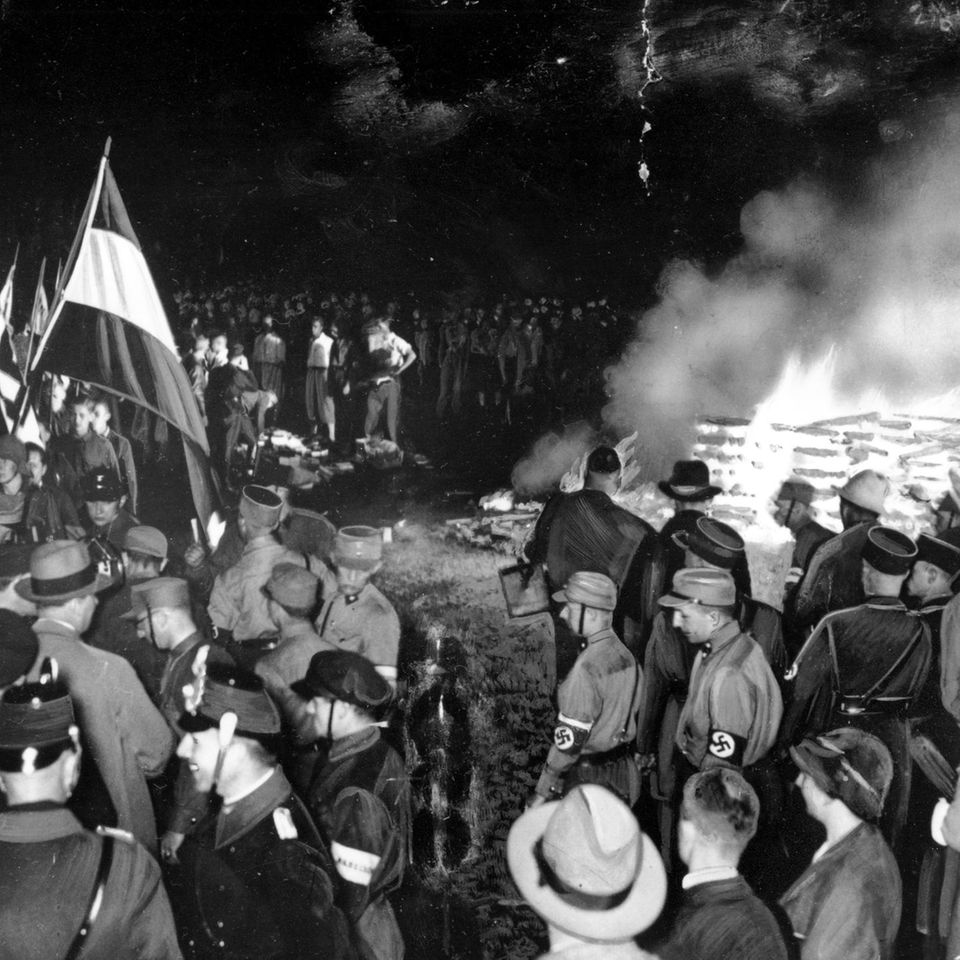 Männer in Nazi-Uniformen verbrennen Bücher (Datum: 10. Mai 1933)