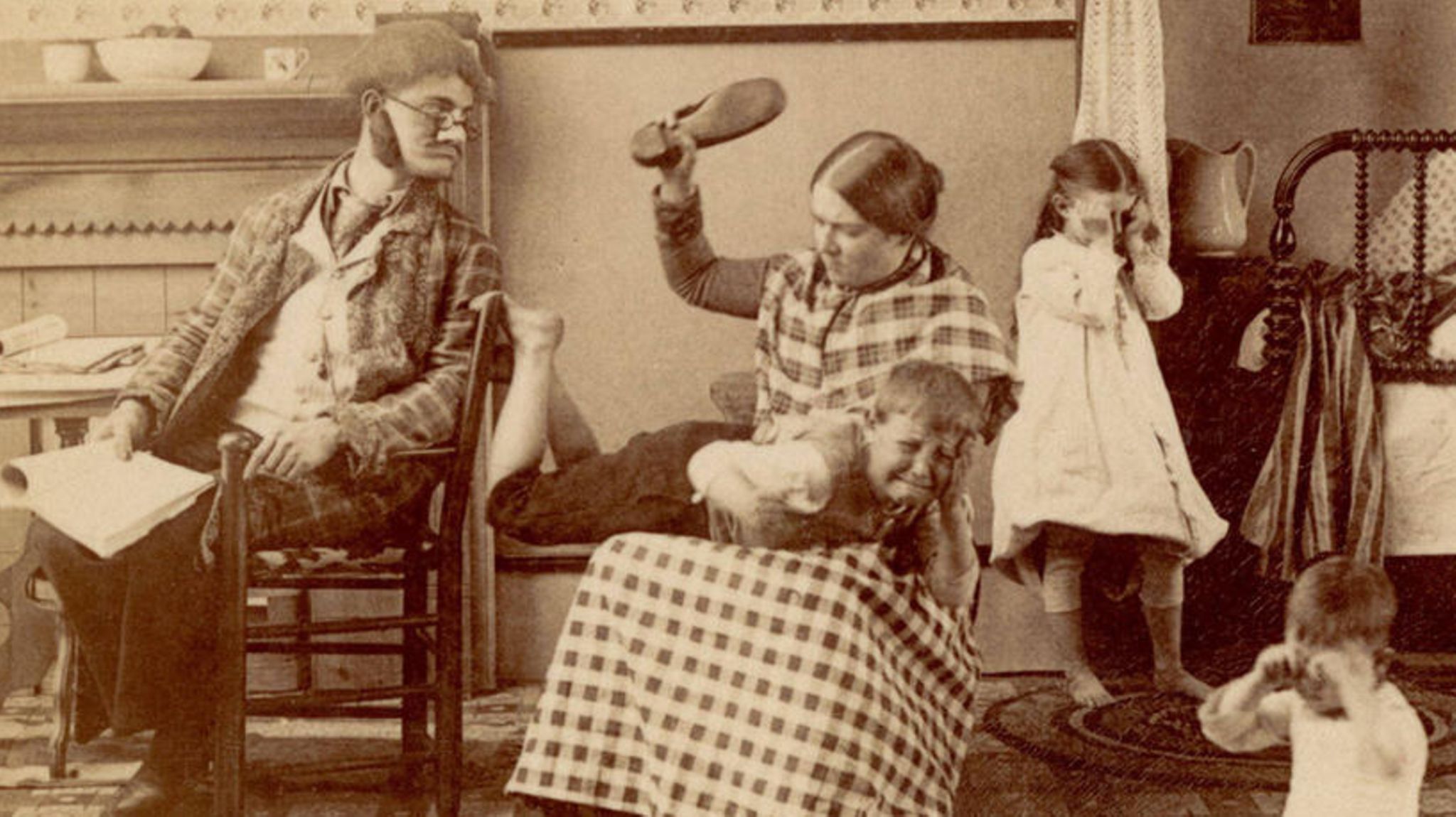 Mutter haut weinenden Sohn mit einem Schuh auf dessen Gesäß