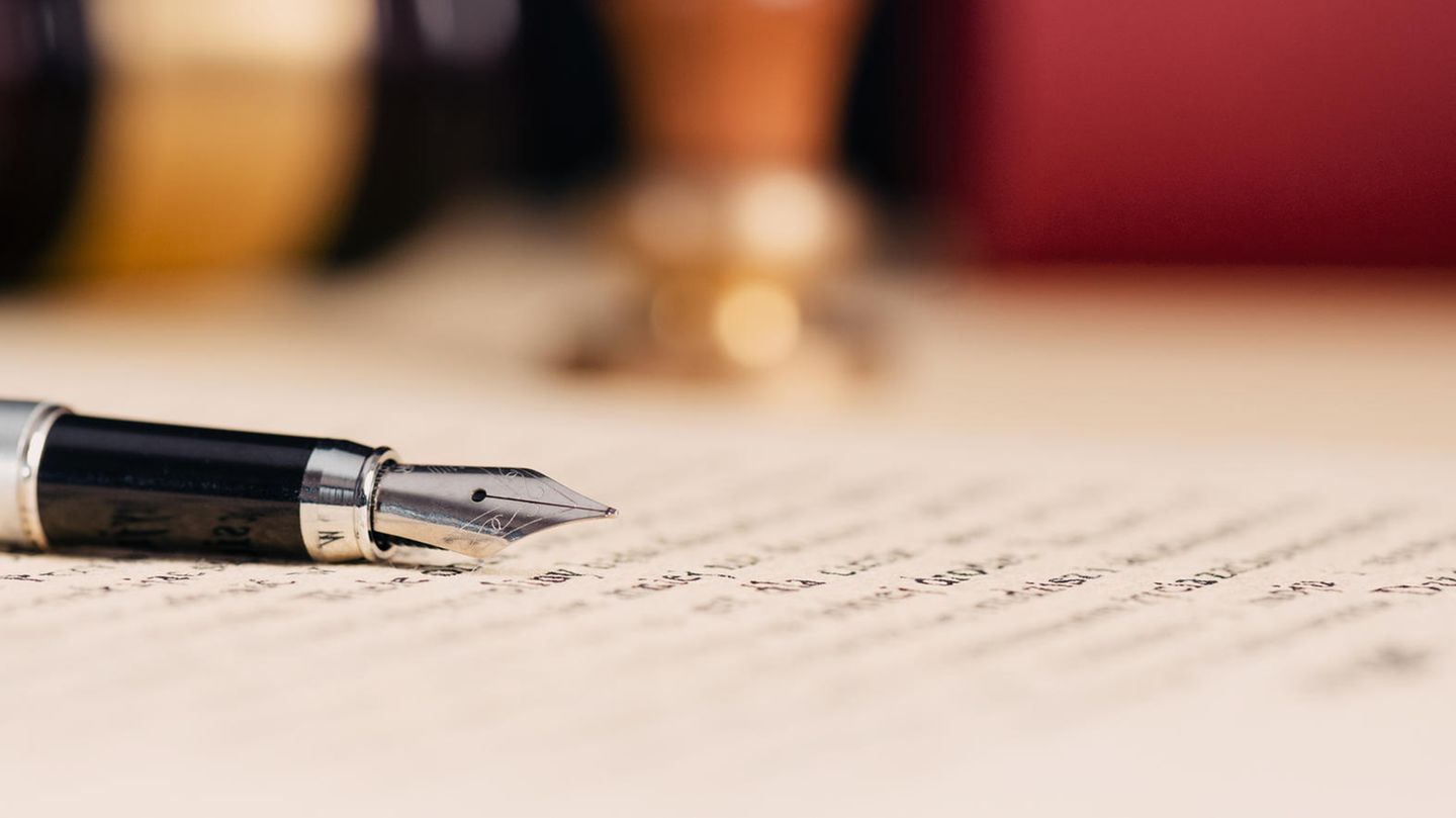 Ein offener Füller liegt auf einem beschriebenen Blatt Papier