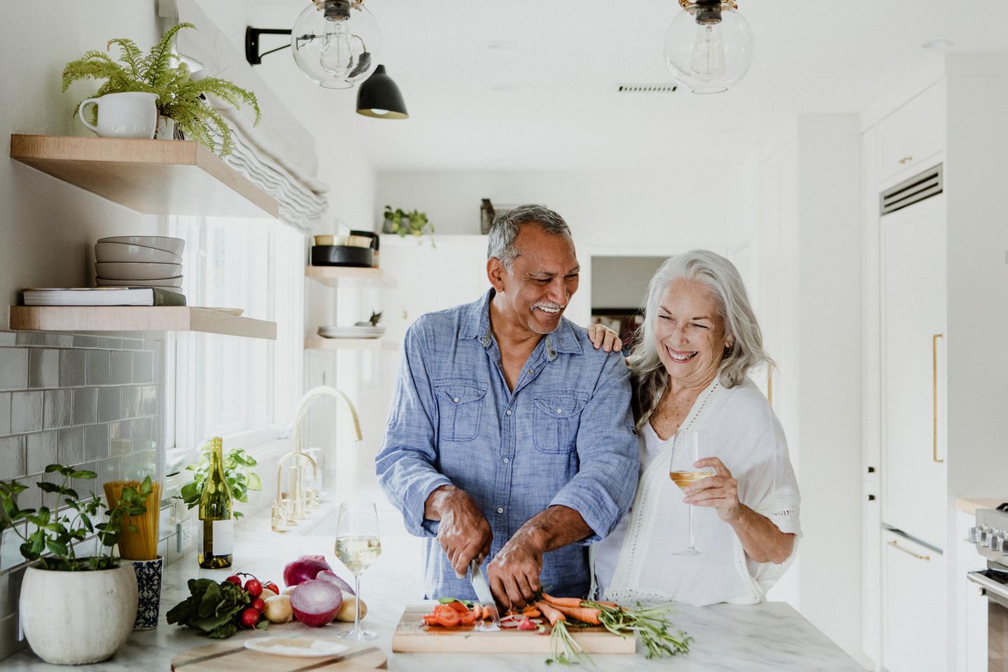 Älteres Paar kocht gemeinsam und lacht