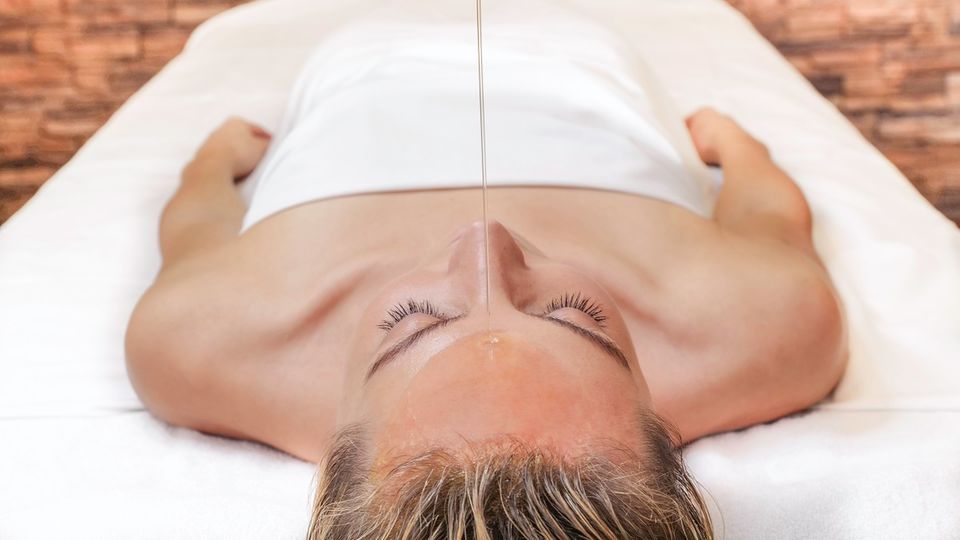 Eine Frau während einer ayurvedischen Anwendung Eine Frau während einer ayurvedischen Anwendung
